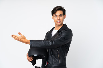 Man holding a motorcycle helmet over isolated white background extending hands to the side for inviting to come