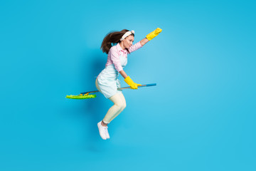 Full length body size view of her she nice attractive strong focused girl maid striving jumping riding broom motivation energy isolated on bright vivid shine vibrant blue color background