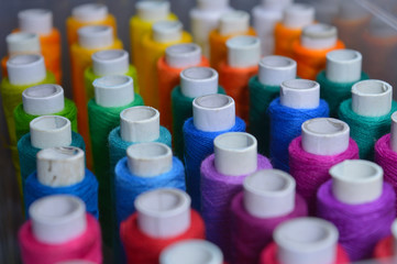 colourful thread rolls arranged in a box