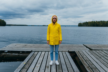 Woman in yellow raincoat on the pier