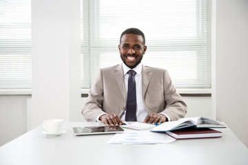 Happy handsome african american businessman smiling while looking at camera in office
