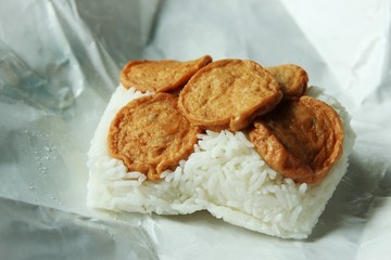 Cooked rice with fried slices of sausage on food wrapping paper, food delivery. photo 