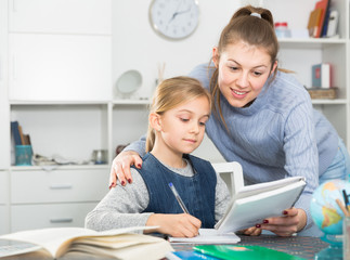 Mother and the teenage daughter do school tasks together at home. High quality photo