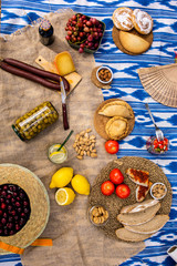 Traditional Majorcan food. Typical cuisine of the Balearic Islands. Picnic with fruit, almonds, pastries and sausages. Top view.