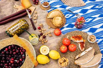 Traditional Majorcan food. Typical cuisine of the Balearic Islands. Picnic with fruit, almonds, pastries and sausages. Top view.
