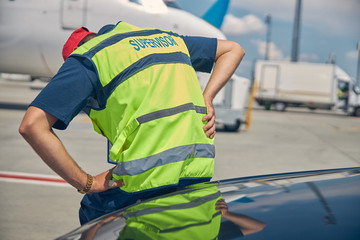 Airport male worker bent double from an acute pain