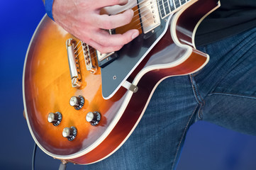 closeup of a musician strumming an electric guitar