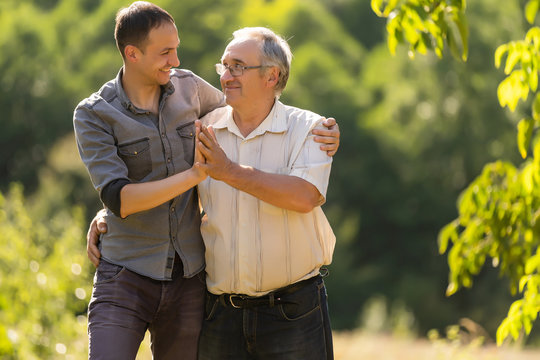 Father and his son looking at the camera in the garden