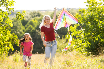 Fototapeta premium Young woman and girl flying a kite