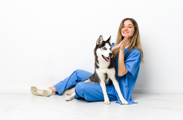 Veterinary doctor with Siberian Husky dog sitting on the floor applauding