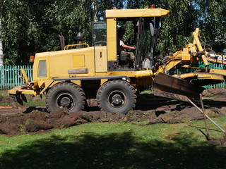 yellow bulldozer at construction site. construction work to repair the road. In the village. Dug-up road