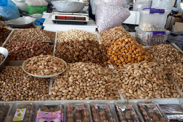 A variety of nuts and dried apricots next to the scales at the Chorsu Bazaar in Tashkent, Uzbekistan. 29.04.2019