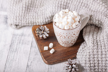 Obraz na płótnie Canvas Mug with coffee and marshmallow, knitted scarf on wooden table. Autumn mood. Cozy autumn composition. Hygge concept - Image