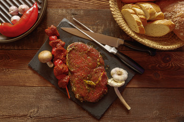 bbq beef skewer with tomato garlic mushroom and slice of spiced meat on slate plate with knife and fork bread basket red chili pepper in grill pan