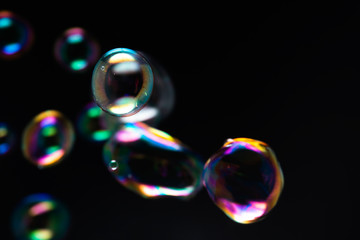 Bubbles abstract background. Colorful, Rainbow soap bubbles float in the dark or black background.