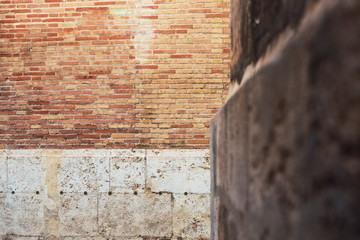 Brick wall focused on the background with defocused stone wall, copy space.