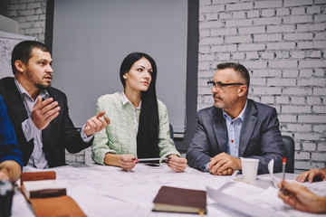 Male and female company directors discussing solutions and new ideas of productive strategy for developing trade.Management team communicating with each other during business conference in office