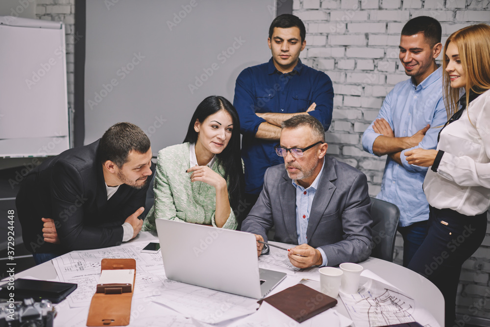 Poster executive experienced director in eyeglasses with team of creative employees working on creating new