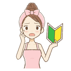 ルームウエアを着た女性が若葉マークを持って困っている　上半身