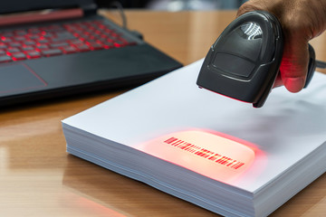 Man hold scanner and scan for reading barcode for transfer data to computer.