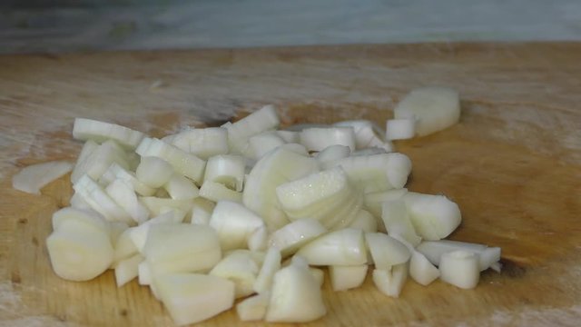 Woman chef cuts garlic with a knife