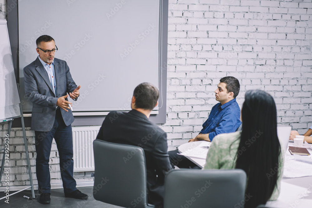 Poster professional coach dressed in formal clothing conducting productive workshop about important busines