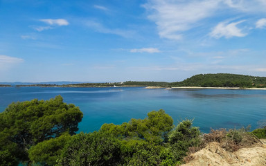 Fototapeta na wymiar Wild beautiful beach with turquoise water, fine sand and large stones. Greece halkidiki bay. Kassandra on the Halkidiki peninsula.