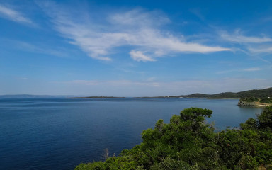 Fototapeta premium Wild beautiful beach with turquoise water, fine sand and large stones. Greece halkidiki bay. Kassandra on the Halkidiki peninsula.