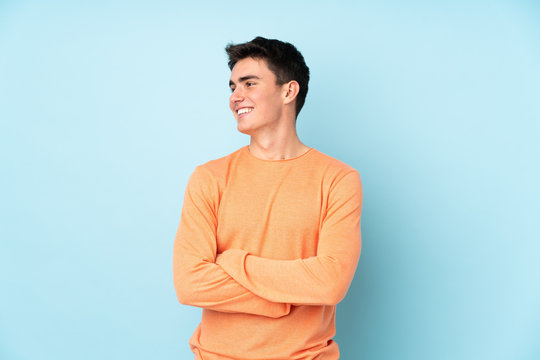 Teenager caucasian handsome man isolated on purple background looking to the side