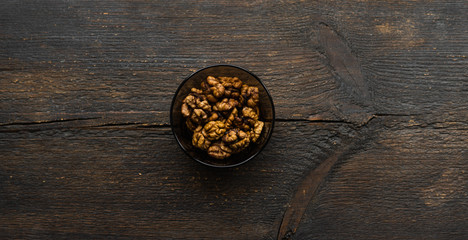 Walnut in a small plate on a vintage wooden table. Walnuts is a healthy vegetarian protein nutritious food. Natural nuts snacks.
