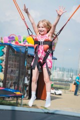 Girl child ride on a swing in a city park