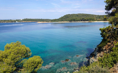 Naklejka premium Wild beautiful beach with turquoise water, fine sand and large stones. Greece halkidiki bay. Kassandra on the Halkidiki peninsula.