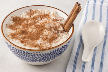 Delicious dessert rise pudding with cinnamon and raisin in bowl, close up view. Served and ready to eat.