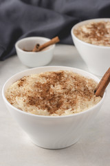 Delicious dessert rise pudding with cinnamon and raisin in bowls, close up view. Served and ready to eat.