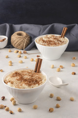 Delicious dessert rise pudding with cinnamon and raisin in bowls, close up view. Served and ready to eat.