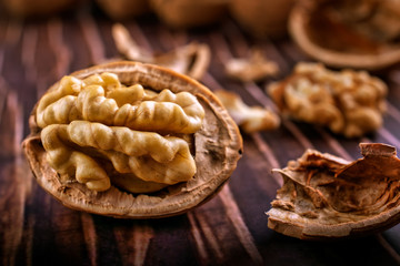 Close-up of walnuts on a rough wooden table, partially opened