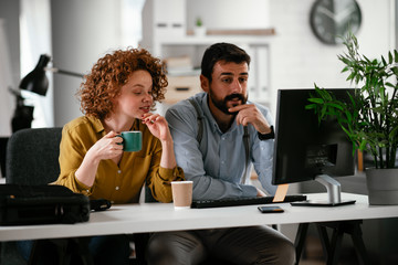 Colleagues in office. Businesswoman and businessman discussing work while drinking coffee