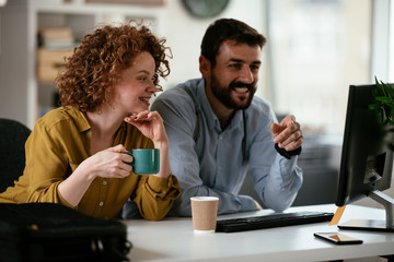 Colleagues in office. Businesswoman and businessman discussing work while drinking coffee