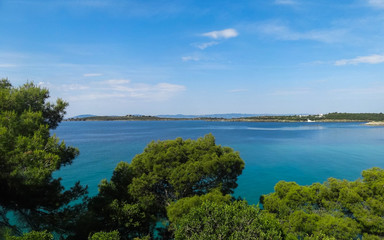 Fototapeta na wymiar Wild beautiful beach with turquoise water, fine sand and large stones. Greece halkidiki bay. Kassandra on the Halkidiki peninsula.