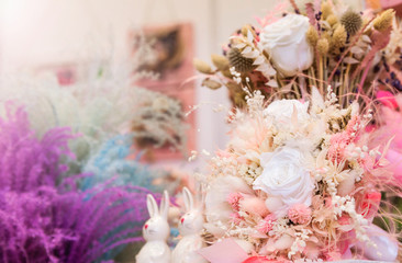 A bouquet of dried flowers as a decor and two porcelain hares next to each other