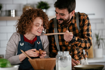 Boyfriend and girlfriend making delicious food at home. Loving couple cooking in kitchen..