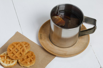 Mug of tea and waffles. On white boards. Autumn still life.