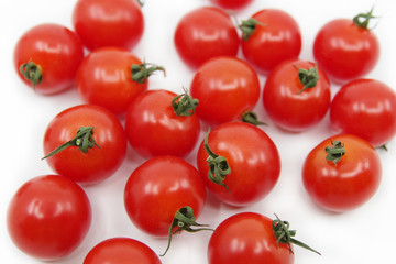 Cherry tomato branch. Cherry tomatoes isolated on a white background. Red tomatoes on a twig on a white background.