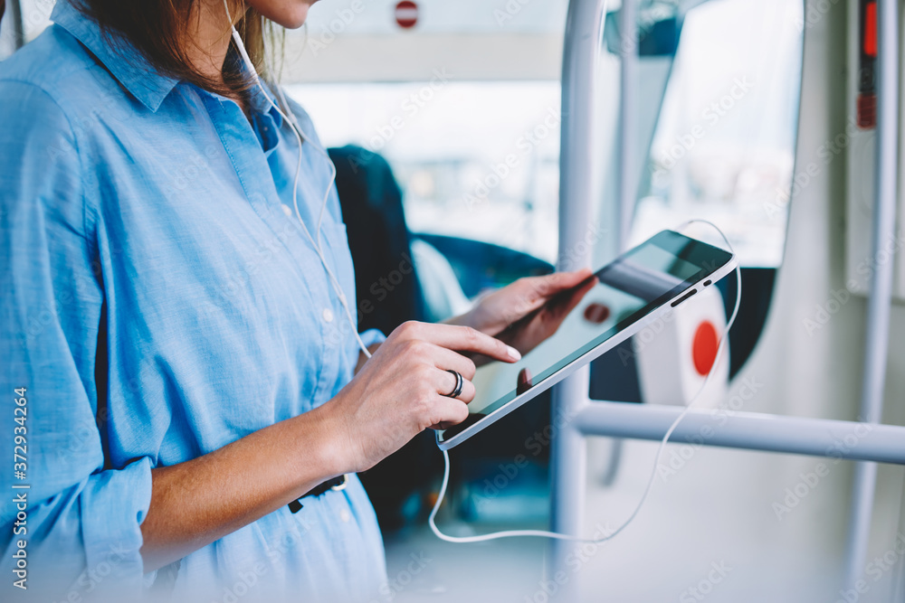 Poster cropped image of woman holding portable pc standing in bus with free wireless connection for browse 