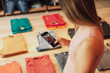 Latin woman owner of small business. Entrepreneurial woman working in her clothing store. Taking...