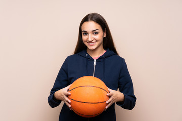 Young woman over isolated background with ball of basketball