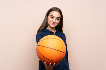 Young woman over isolated background with ball of basketball