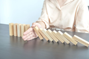 Woman hand stop wooden blocks for protect other wooden block, Concept Risk of management and strategy plan
