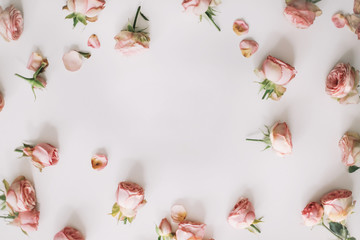 Floral composition with frame of pink rose flowers on white background. Flat lay, top view mockup, copy space template