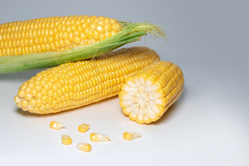The peeled ear of corn, a piece of and seeds on a white, isolated